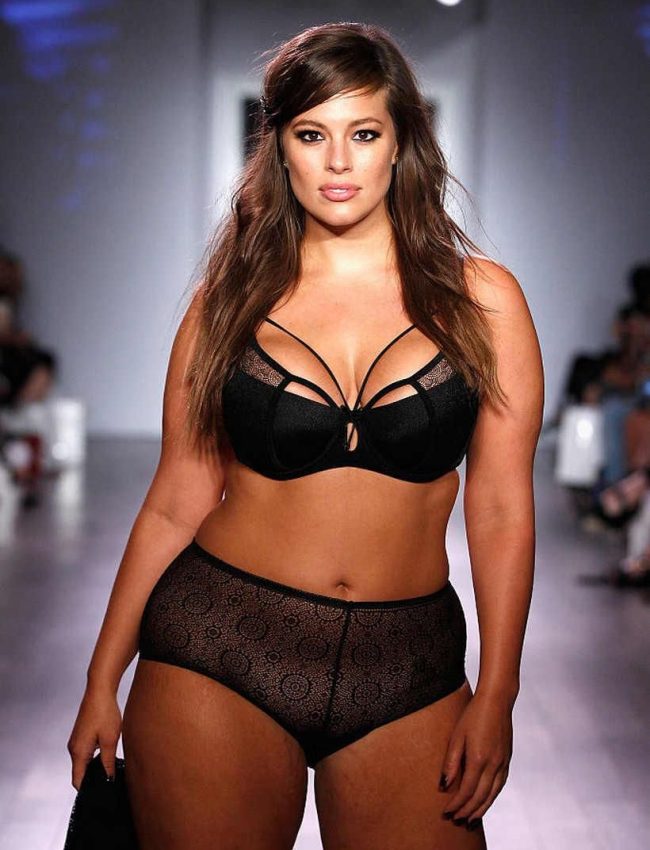 דוגמנית צועדת על המסלול בתצוגת אופנה, לובשת סט הלבשה תחתונה שחור עם עיצוב מחורר.